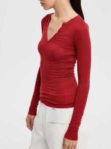 Side view of red V-neck long sleeve slim knit top with fine texture on model