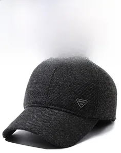 Detailansicht des grauen strukturierten Stoffes und Metall-Logos auf der Wintermütze