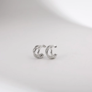 Close-up of silver-tone stainless steel twisted hoop earrings with a triple-layered C-shape design