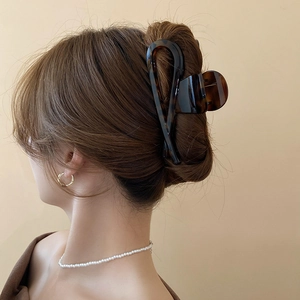 Detail of a large tortoiseshell hair claw clip securing a vintage elegant updo hairstyle