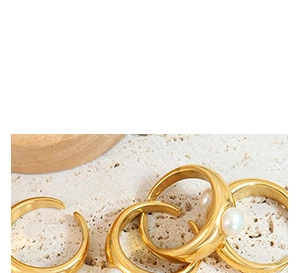 Close-up of vintage gold rings with natural freshwater pearls on a stone surface