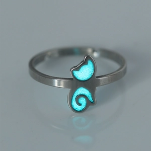 Close-up of silver steel ring featuring a glowing blue cat motif in a dark setting