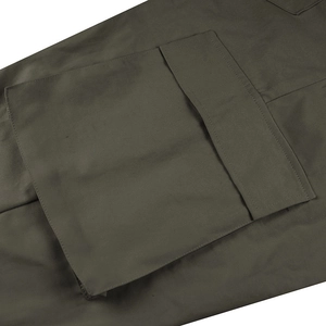 Detail of the olive green cargo pants showing large utility pockets and durable stitching