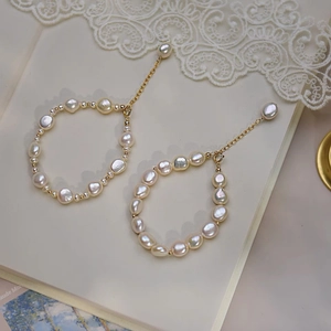 French baroque pearl drop earrings in 14K gold with vintage lace background