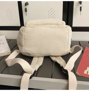 Detailansicht der Cord-Struktur und der stabilen Schultergurte eines weißen Rucksacks
