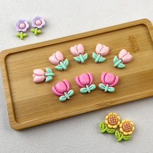 Glossy resin tulip and sunflower DIY accessories arranged on a light wooden tray