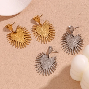 Detailed view of cactus-shaped stud earrings in gold and silver finish with radial patterns