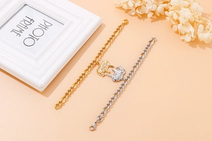 Detail of gold and silver elephant charm bracelets on a textured background