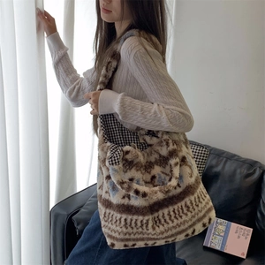 Ethnic plush tote bag in brown and beige geometric pattern worn by a model in a cozy room