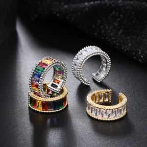 Detailed macro of gold and silver open rings with baguette cut rainbow zircons and beaded edge