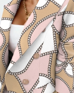 Dettaglio del blazer con stampa a catena, blocchi di colore beige e bottoni in rilievo
