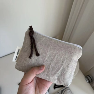 Close-up of herringbone texture on natural cotton coin purse with simple wish label