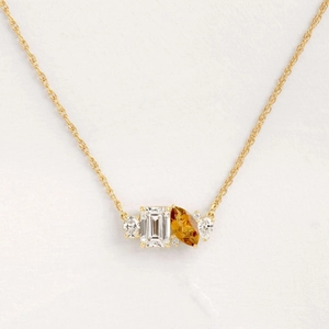 Gold pendant necklace with emerald-cut clear stone and marquise amber gemstone