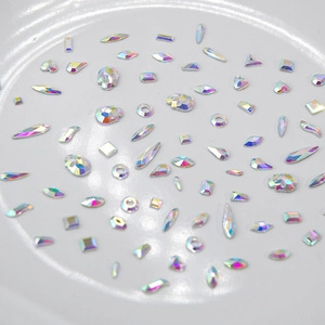 Assorted K9 AB crystal rhinestones in various shapes for DIY nail art on white plate