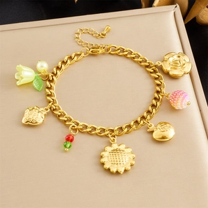 Détail du bracelet doré avec pendentifs de tournesols et fleurs sur boîte de présentation