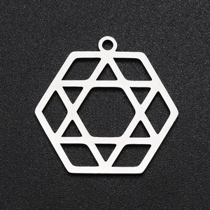 Macro shot of silver stainless steel hexagonal pendant with cutout hexagram pattern