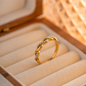 Elegant 18K gold-plated braided twist ring with pearl accents on velvet jewelry tray