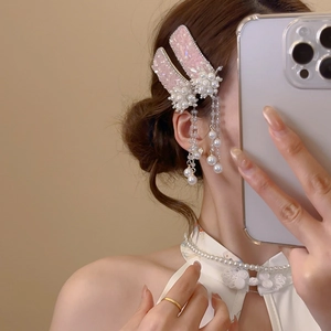 Detail of pink crystal flower hair clip with elegant long pearl tassels on a model