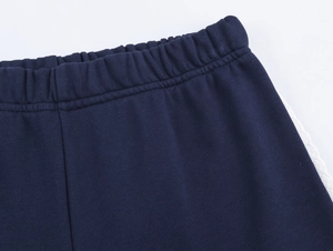 Détail du jogging bleu marine avec taille élastique et dentelle blanche latérale