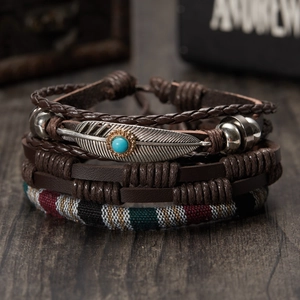 Men's brown leather bracelet set with woven ropes and turquoise bead on wooden desk