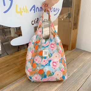 Dettaglio della borsa shopper in tela a fiori colorati con trama in rilievo e etichetta LOVE