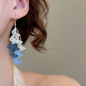 Close-up of model wearing gradient blue hollow butterfly tassel earrings with metal hooks