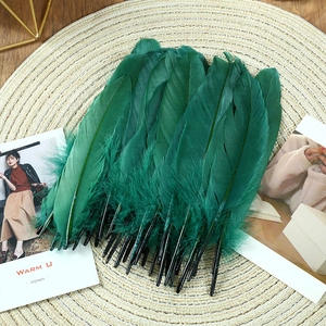 Close-up of deep green goose feathers for DIY crafts on a rustic woven mat surface