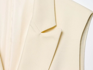 Détail du revers et de la texture tissée du gilet ample pour femme en couleur crème