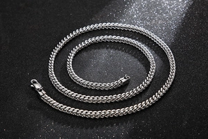Macro detail of silver snake chain necklace with four-side grinding on black background