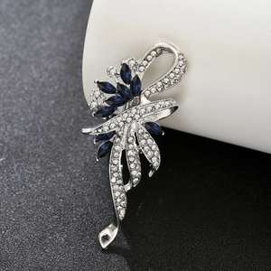 Macro detail of silver floral brooch with blue marquise gems and sparkling rhinestones