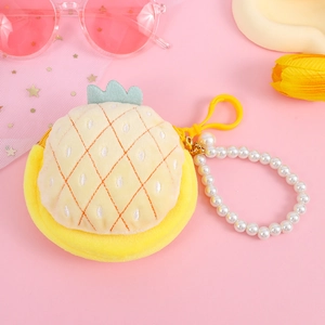 Detail of plush pineapple coin purse with pearl chain and green leaf crown on pink background