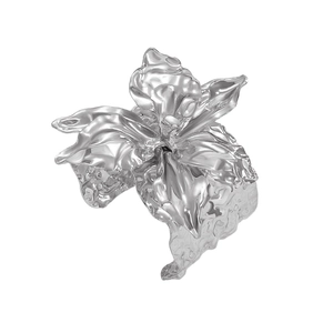 Dettaglio di un anello a fiore argento con petali irregolari e lucentezza metallica