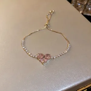Elegant gold bracelet featuring a pink heart zircon with sparkling white diamond halo
