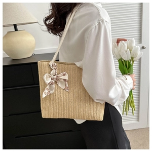 Sac fourre-tout en paille avec foulard en soie géométrique dans un décor minimaliste