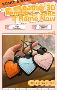 Detailed view of heart-shaped leather keychains in orange, blue, and pink with stitching