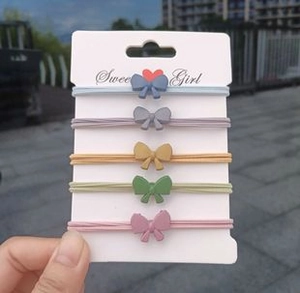 Close-up of five colorful Morandi elastic hair ties with matte resin bow decorations