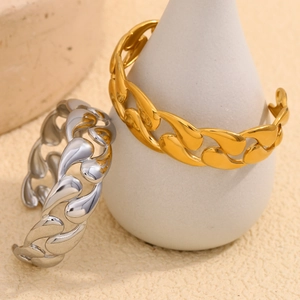 Macro view of high-polish gold and silver interlocking chunky Cuban link bracelets