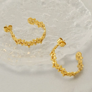 Chic hollow star-shaped stainless steel hoop earrings in gold on clear glass display