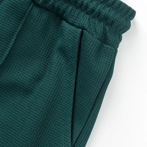 Detalle de los pantalones cortos de punto gofrado verde oscuro con cintura elástica