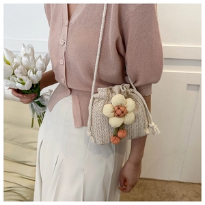 Dettaglio mini borsa a secchiello in paglia con decorazioni floreali 3D e coulisse