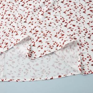 Détail de la robe à fleurs blanches montrant l'ourlet arrondi et les coutures précises