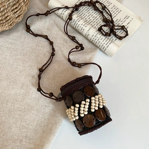 Detail of bohemian round crossbody bag with coconut shell discs and tiered wooden beads