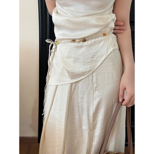Détail d'une chaîne de taille tissée à la main avec perles en bois sur robe en satin