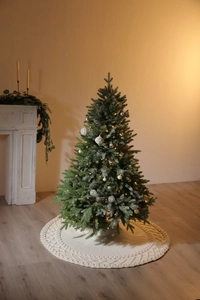 Gros plan du cache-pied de sapin de Noël blanc tricoté avec motifs de losanges