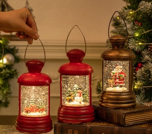 Close-up of vintage Christmas lantern with LED snow globe scene on antique books
