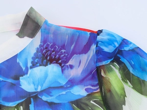 Detailed view of floral chiffon fabric with blue flower print and ruffled collar