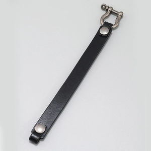 Detailed close-up of a black genuine leather strap with a polished metal horseshoe buckle