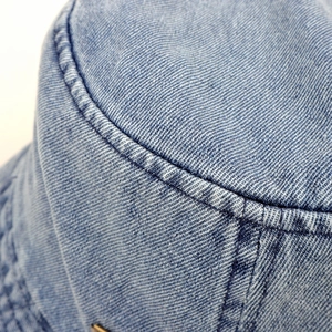 Close-up of light blue denim bucket hat showing twill texture and precision stitching detail