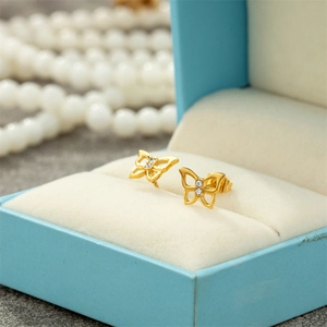 Elegant gold butterfly earrings with cubic zirconia in a blue jewelry box display
