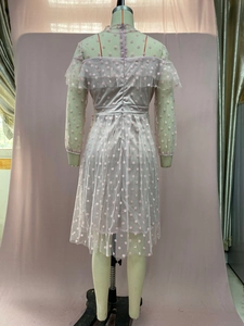 Close-up of pink polka dot mesh evening dress showing ruffle trim and layered fabric
